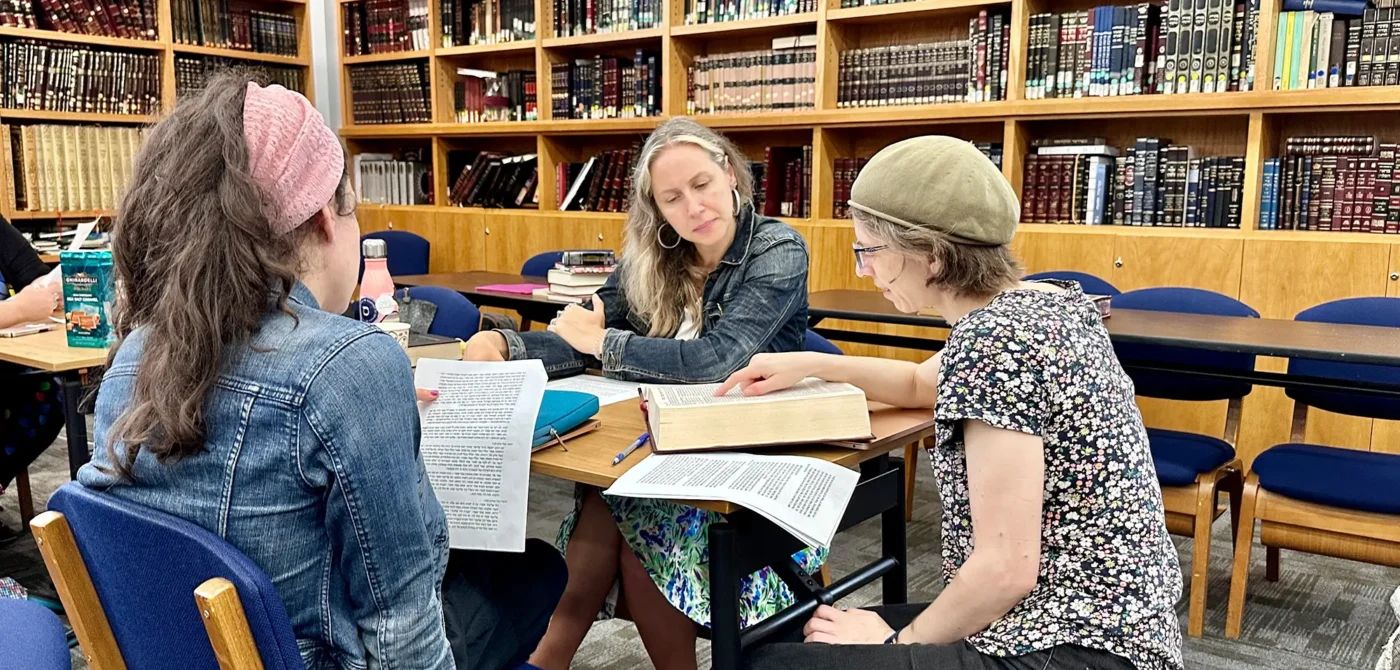 Visit Page Hero Image - Students Around a Table