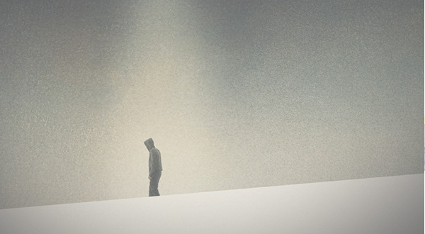 Lone figure standing in front of a neutral background