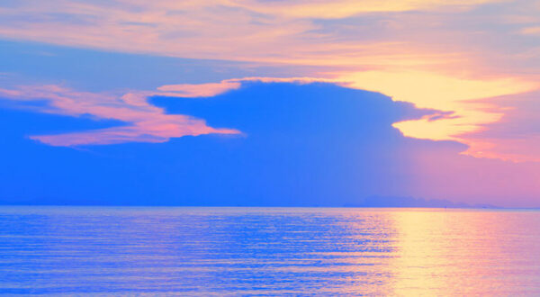PURPLE AND YELLOW PHOTOGRAPH OF THE SKY AND WATER BELOW